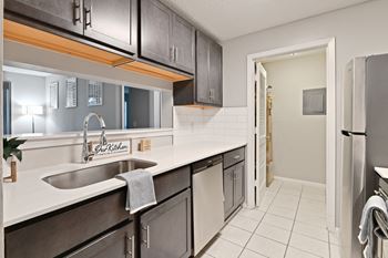 a kitchen with stainless steel appliances and white countertops and a door to a hallway at Waldan Pond Apartments, Acworth, 30102